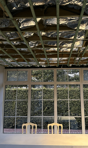 Tijdens de werken: houten latten en isolatie zichtbaar aan het plafond.