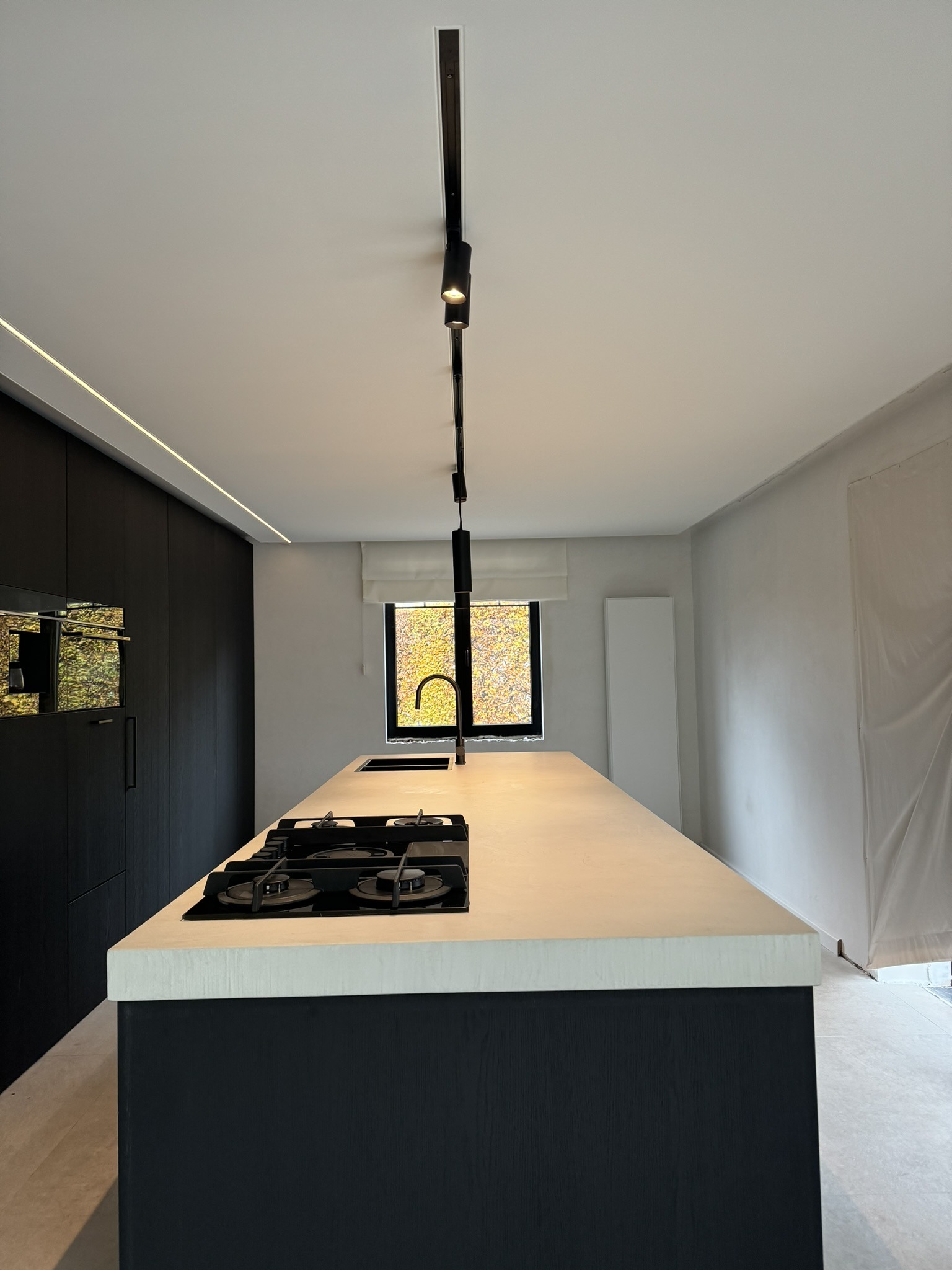Naadloos wit spanplafond boven een moderne keuken met kookeiland — realisatie KP-Label