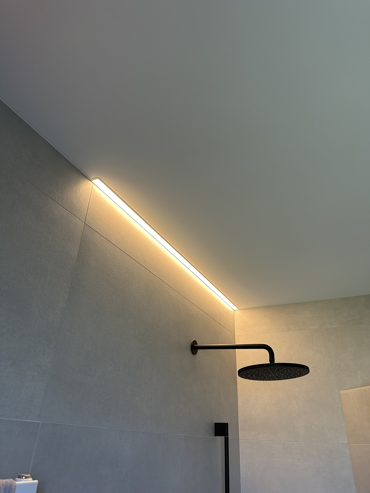 Badkamer met geïntegreerde lichtwand en strak spanplafond — realisatie KP-Label